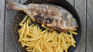 Eine leckere Dorade mit knusprigen Pommes, serviert in einer Eisengusspfanne, zubereitet nach dem Rezept Fish and Chips - mediterrane Art von schonzeitvertreib.de