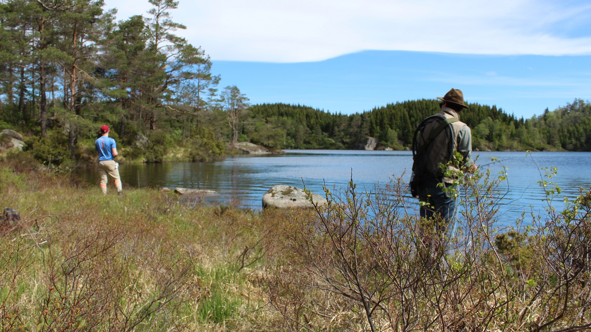 Zwei junge Männer angeln bei strahlend blauem Himmel im Hellavatnet bei Oyslebo