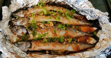 Ein geöffnetes Alufolienpaket bringt die Makrele - vietnamesischer Art nach dem Rezept von schonzeitvertreib.de zum Vorschein, garniert mit Lauchzwiebeln und Erdnüssen