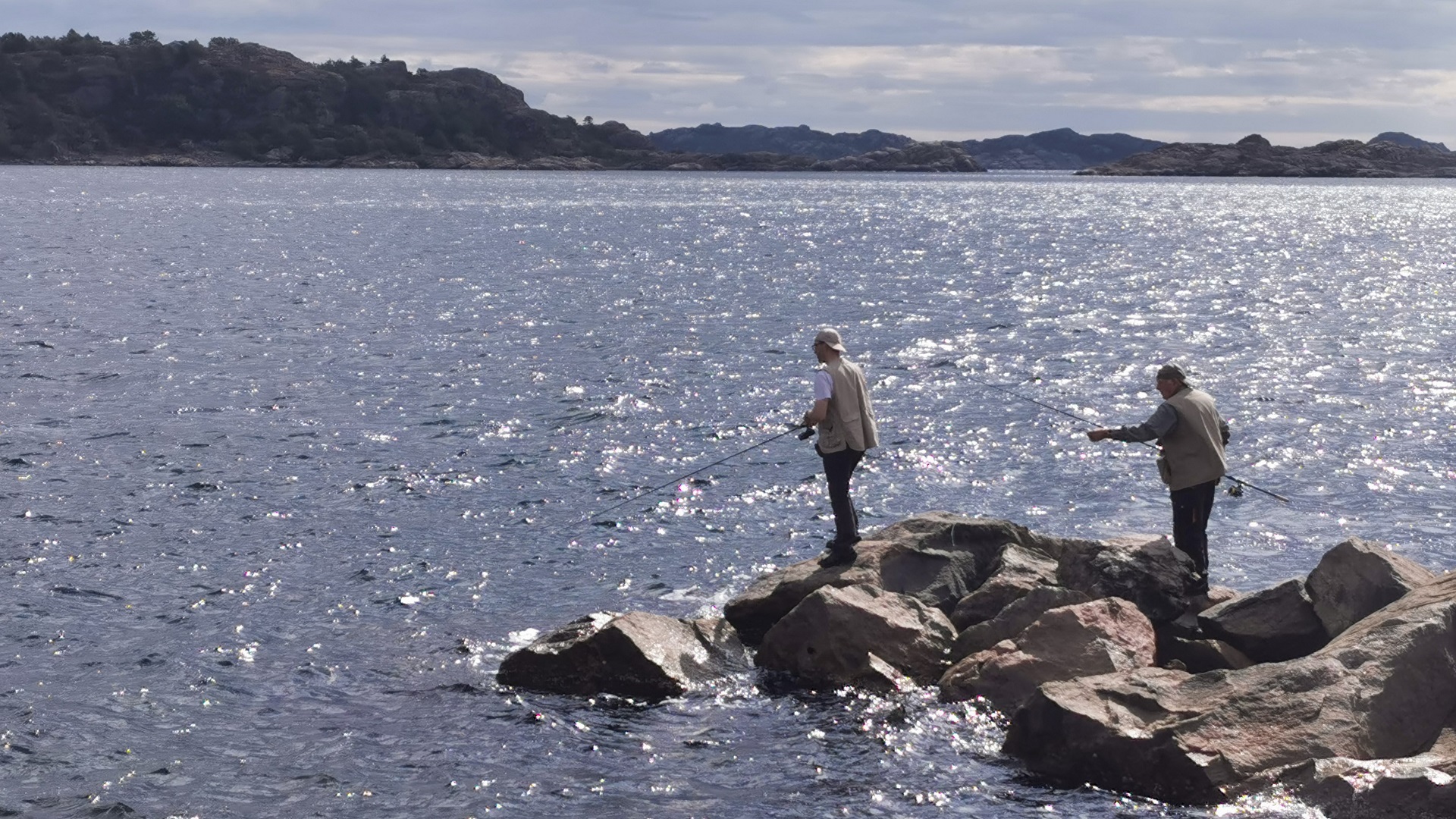 Zwei Männer angeln in Båly Brygge bei Spangereid und genießen dabei grandioses Wetter