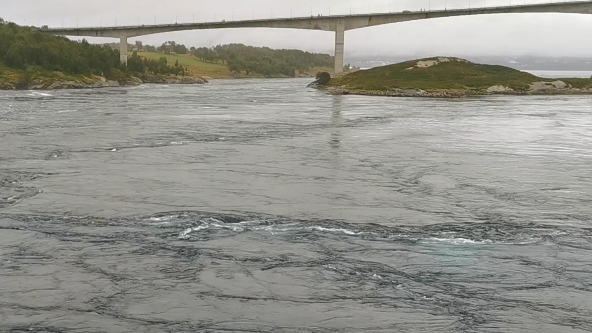 Im Vordergrund beim Angeln zu beobachtende, faszinierende Wasserbewegungen und im Hintergrund die Brücke über den Saltstraumen bei Bodø