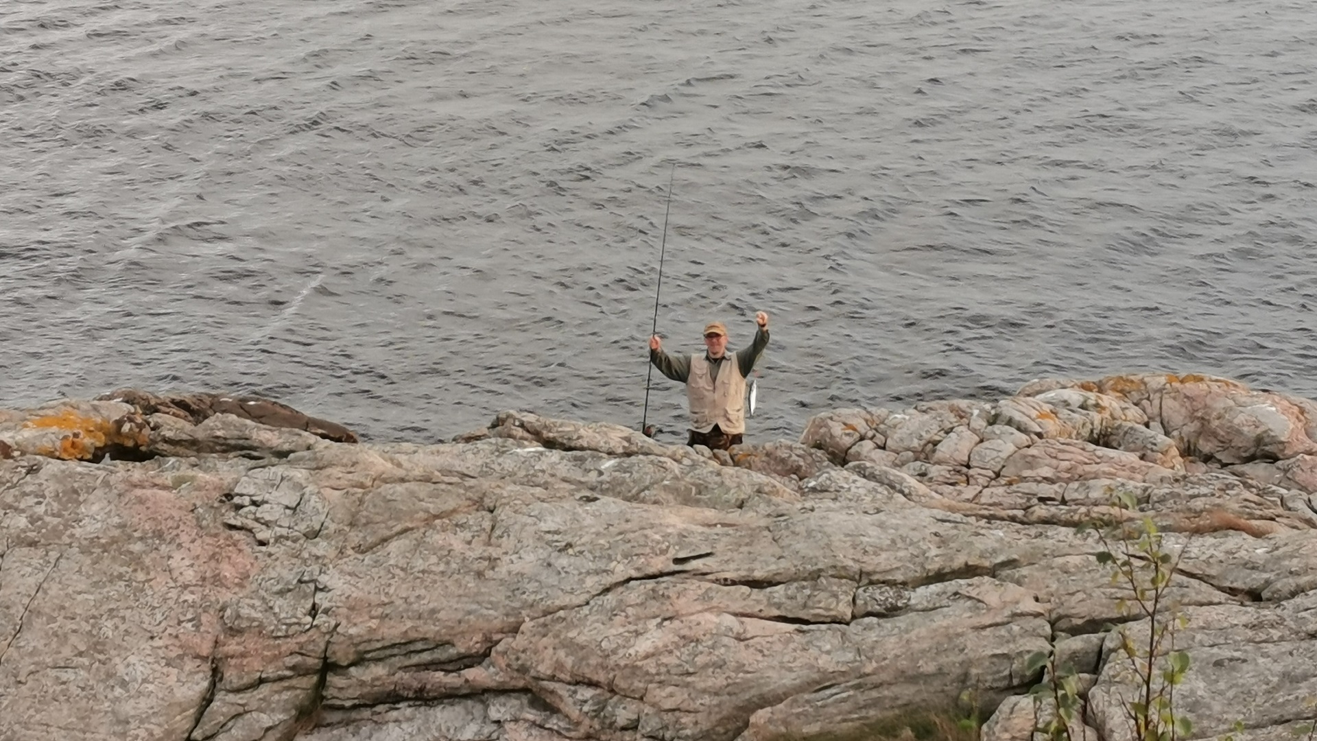 Ein Mann präsentiert freudig eine beim Angeln in der Lussevika bei Åvik gefangene Makrele