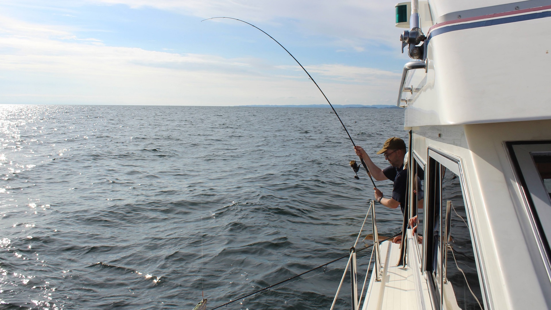 Die Rute eines Anglers krümmt sich an einem Offshore-Spot bei Ryvingen