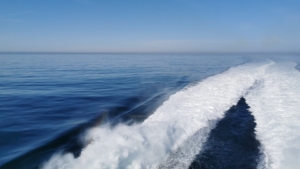 Fantastischer Blick auf blaues Meer unter blauem Himmel. Durch die Maschinen der Fähre zieht sich eine weiß schäumende Schneise durch das Wasser