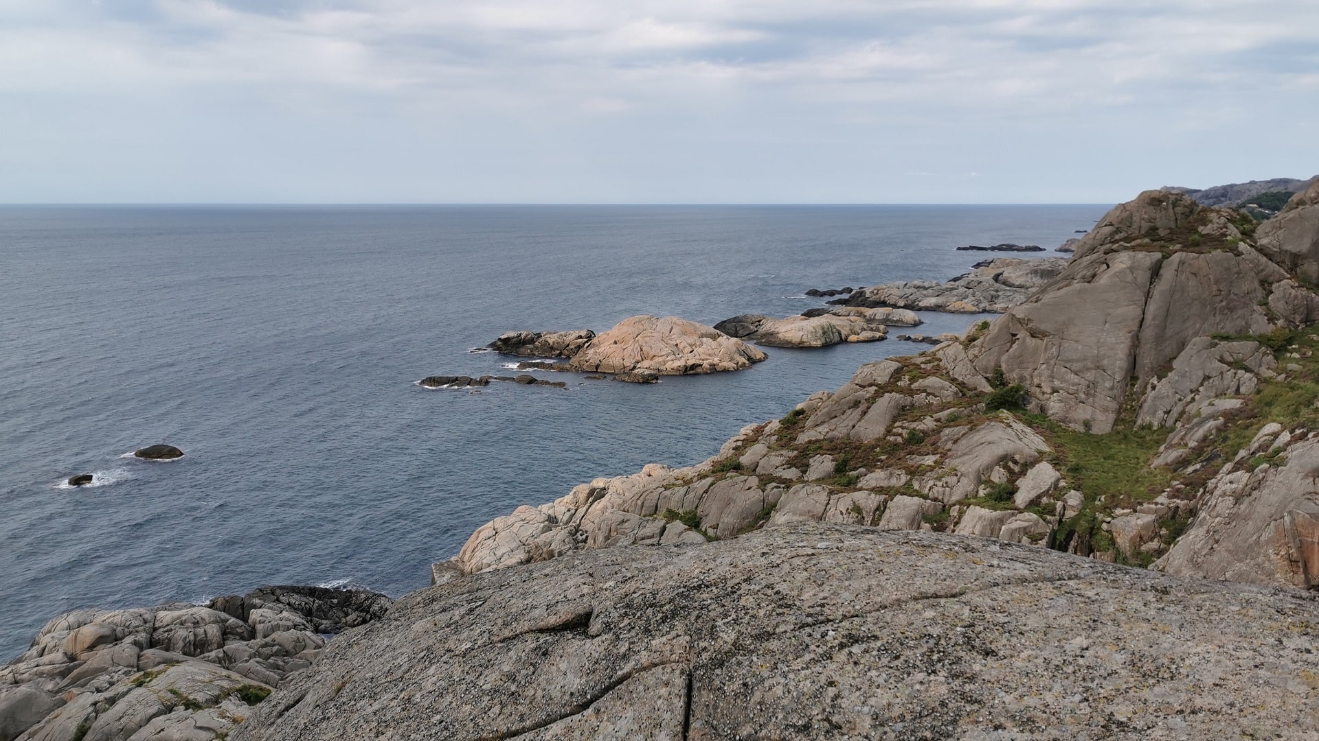 Blick von einem Felsen in Vagan bei Hauge i Dalane auf eine kleine Inselformation im Meer