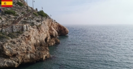 Ein malerischer Küstenweg entlang des felsigen Ufers zwischen Rincón de la Victoria und Cala del Moral, mit dem Mittelmeer zur Rechten, eingehüllt in einen sanften Dunst, der über dem ruhigen Wasser liegt – eine idyllische Kulisse für das Spinnfischen in der Nähe von Malaga, Andalusien.