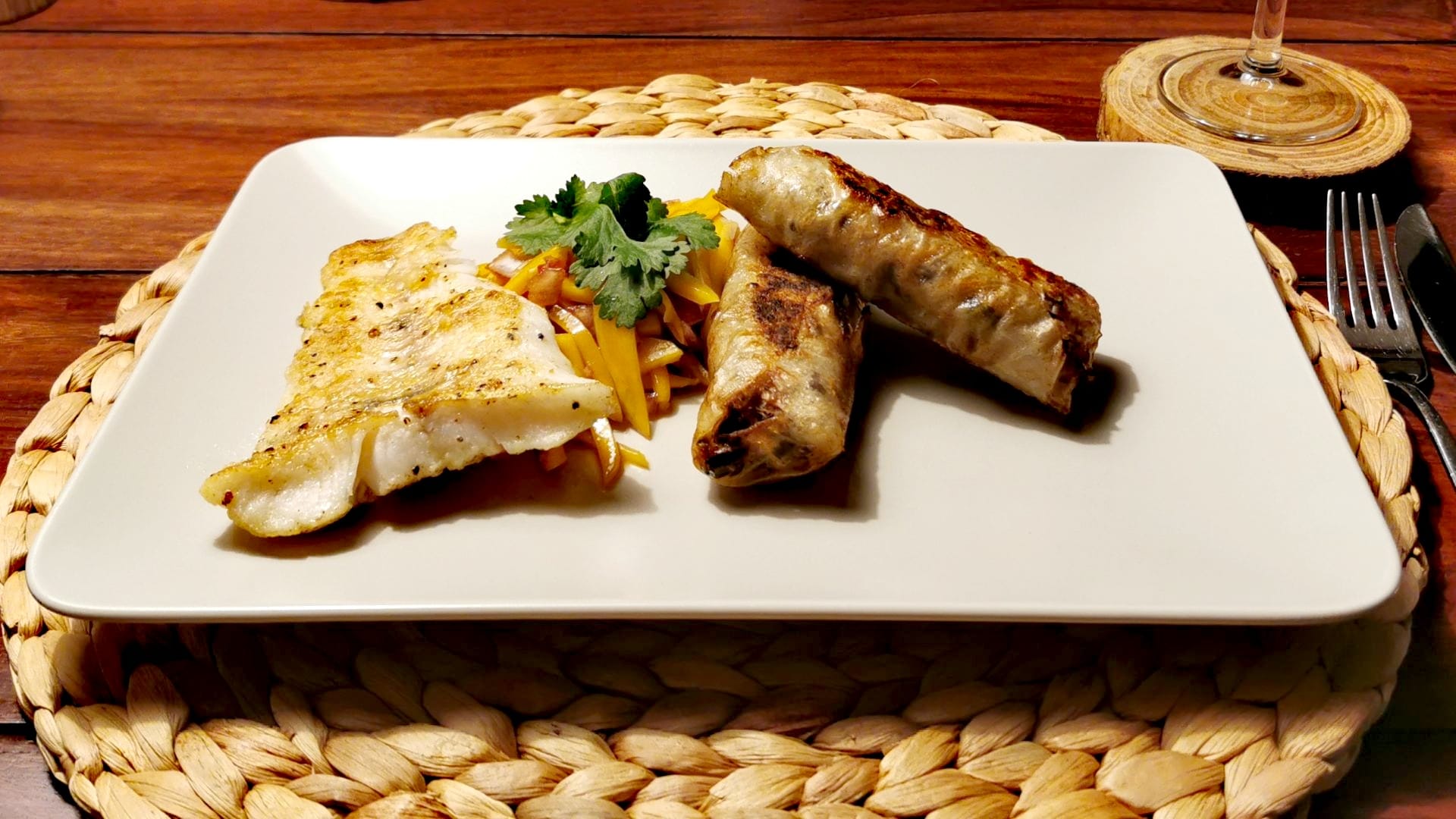 Nachdem das Rezept fertig umgesetzt wurde, sind ein Stück Zander-Filet, zwei vietnamesische Nem und der Mango-Salat asiatisch-dekorativ auf einem Teller angerichtet