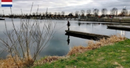 Angeln an der Schleuse in Roermond – Spinnfischer am Wasser bei bewölktem Himmel in einem beliebten Angelrevier der Niederlande