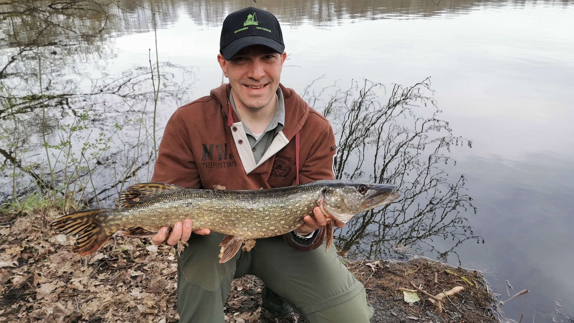 Ein Angler hält stolz einen kräftigen Hecht in die Kamera – gefangen beim gezielten Angeln im Summter See, wo sich Raubfische in strukturreichen Bereichen aufhalten.
