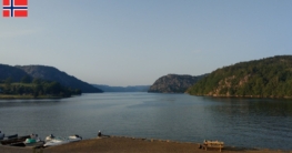 Eine Frau genießt beim Angeln den Blick vom Bootsanleger im Süden über die Høllebukta bei Spangereid