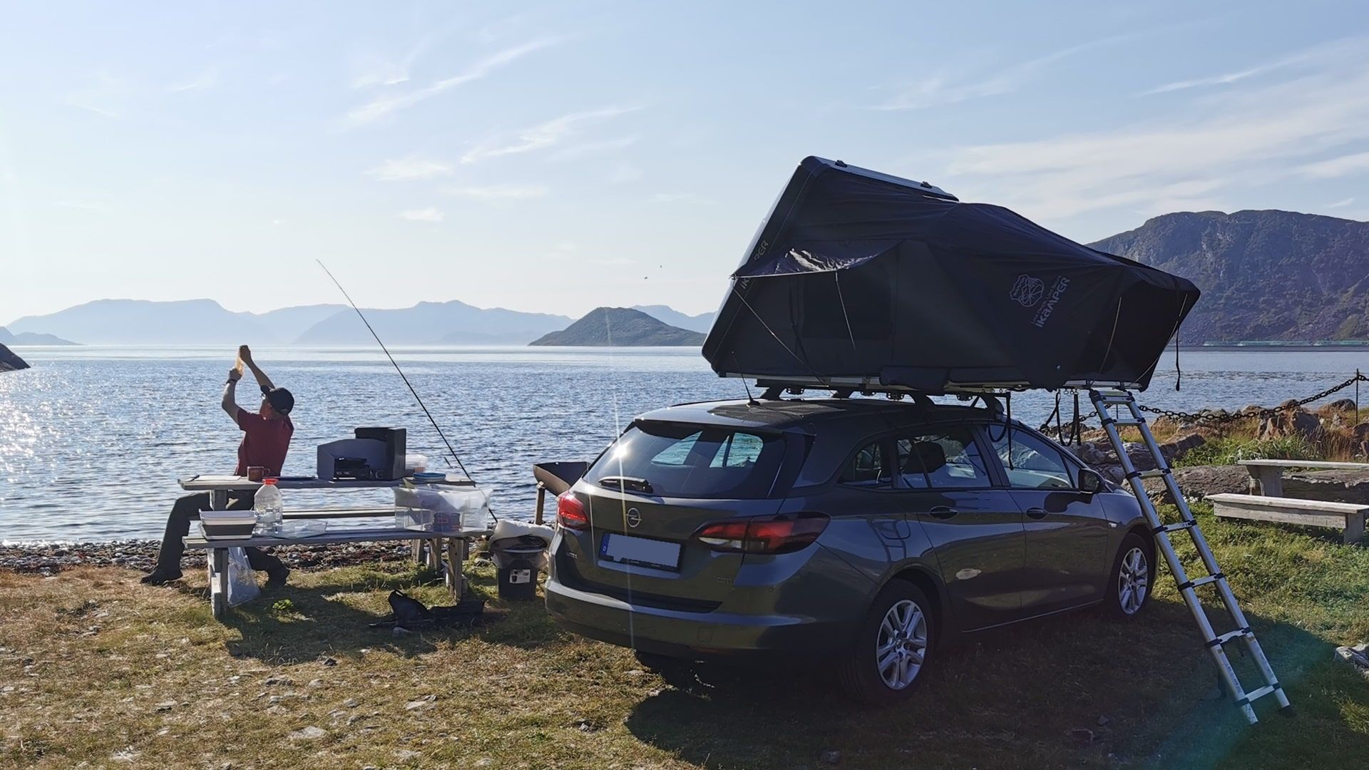 Auto mit Dachzelt an der Scenic Picnic Area Seiland, daneben Sitzgruppe und Utensilien zum Angeln