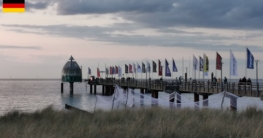 Seebrücke Zingst im sanften Licht des Sonnenaufgangs mit wehenden Fahnen – ein beliebter Ausgangspunkt für das Angeln auf Hornhecht rund um Zingst