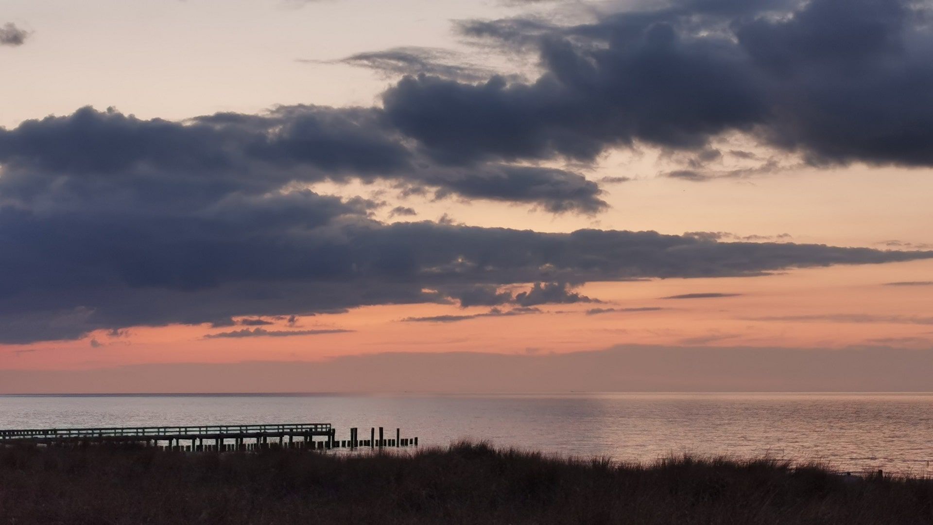 Rötlich gefärbter Himmel über dem Ostseestrand an der Seebrücke Zingst – ideale Kulisse für frühes Hornhecht-Angeln bei ruhiger See