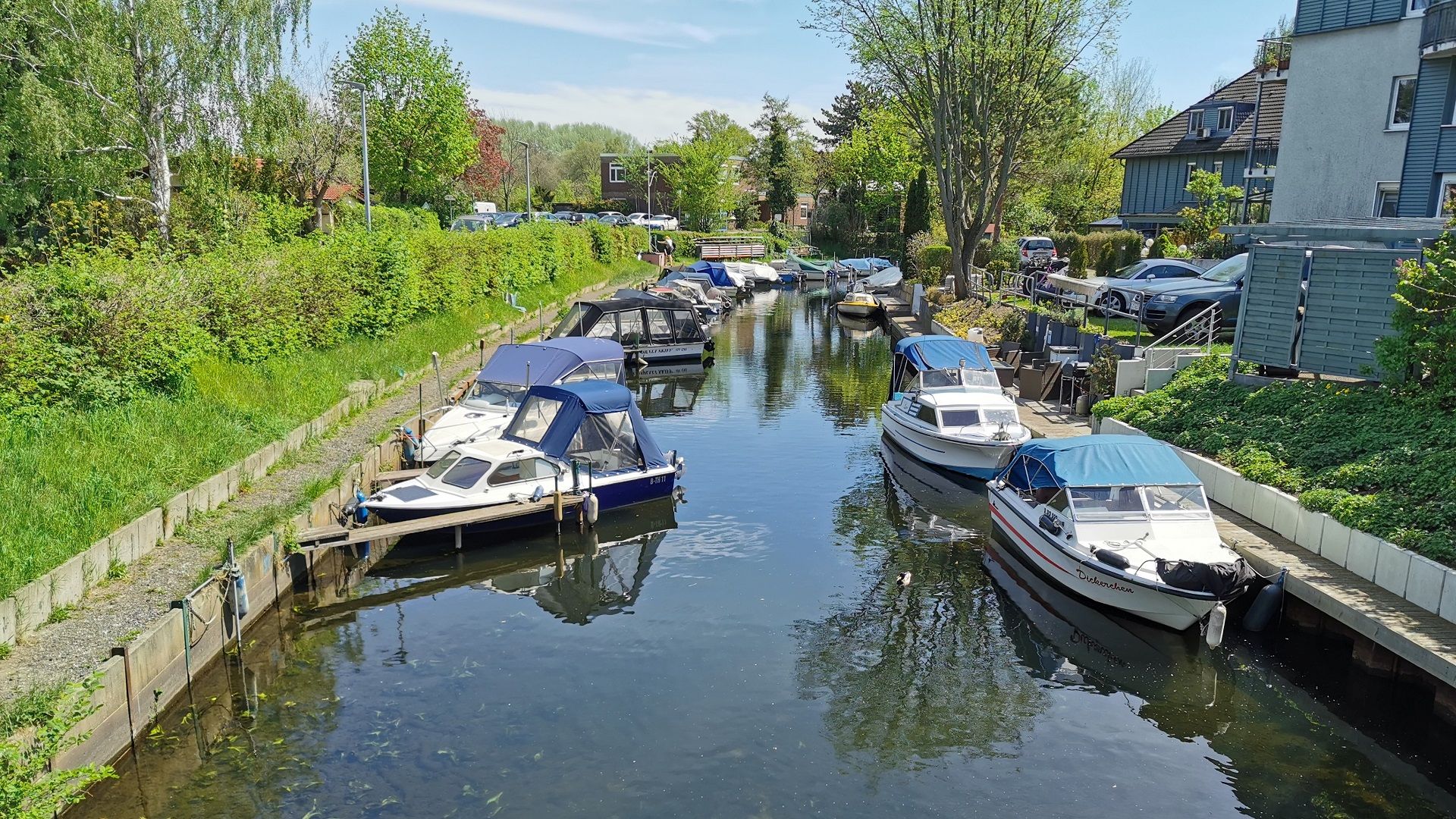 Blick von der Brücke am Tiefwerderweg auf den Großen Jürgengraben – zahlreiche Boote liegen vertäut am Ufer, typisch für die charmante Umgebung beim Angeln in Klein-Venedig inmitten der Tiefwerder Wiesen