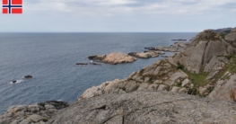 Aussicht vom Felsen auf die vorgelagerten Inseln und das raue Felsufer von Vågan bei Hauge i Dalane – eine typische Küstenlandschaft beim Angeln unter leicht bewölktem Himmel