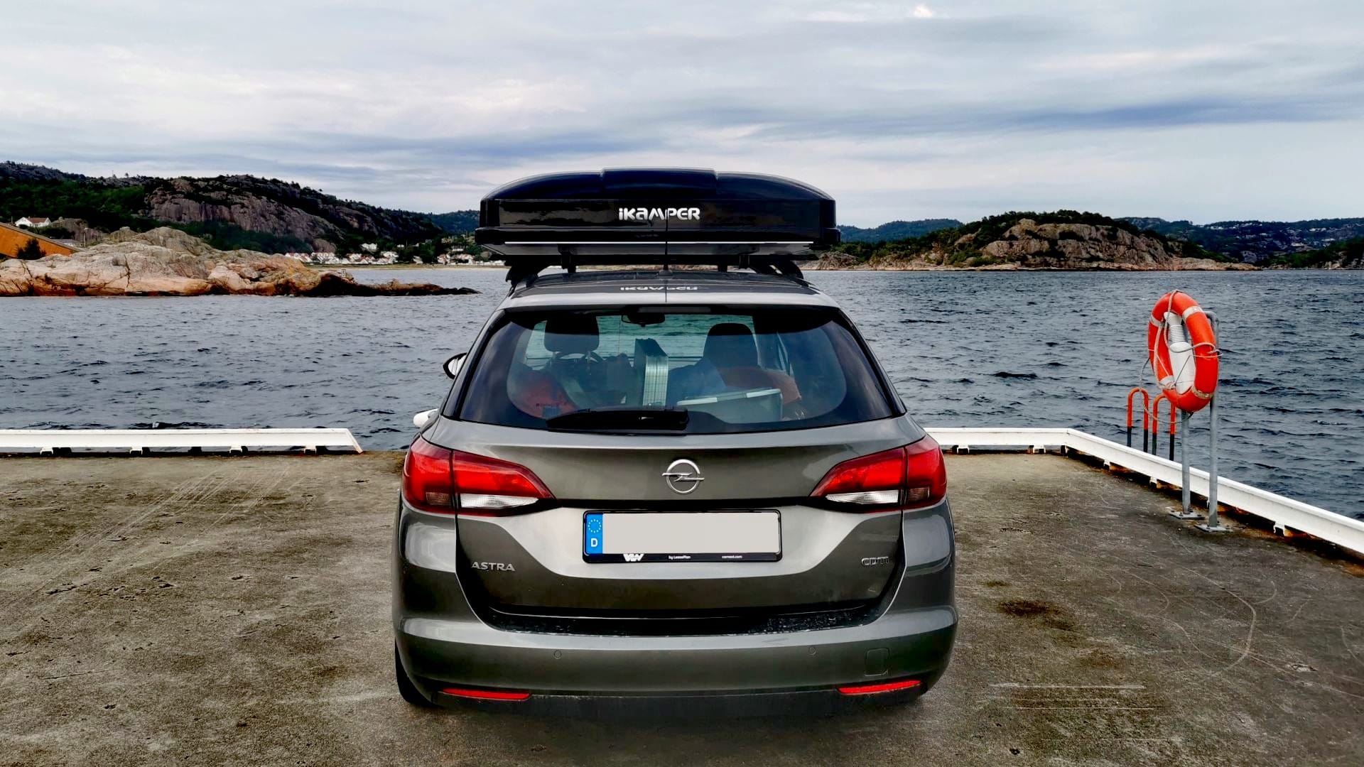 Opel Astra K Sports Tourer mit aufgebautem iKamper Dachzelt steht auf einem kleinen Kai bei Spangereid, bereit für die Weiterreise Kristiansand