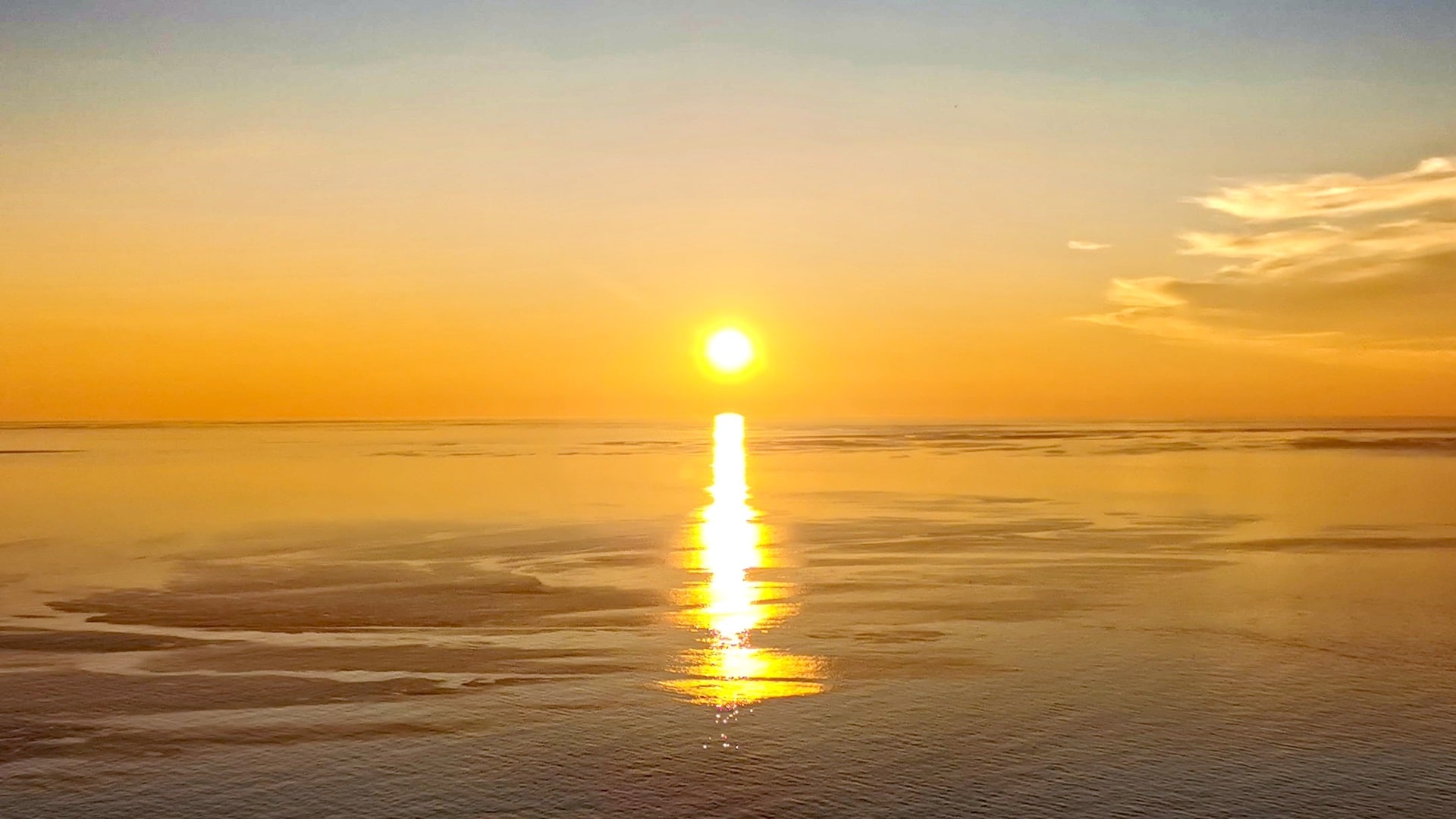 Die Mitternachtssonne taucht den Himmel und das Meer am Nordkap in ein warmes, goldenes Licht