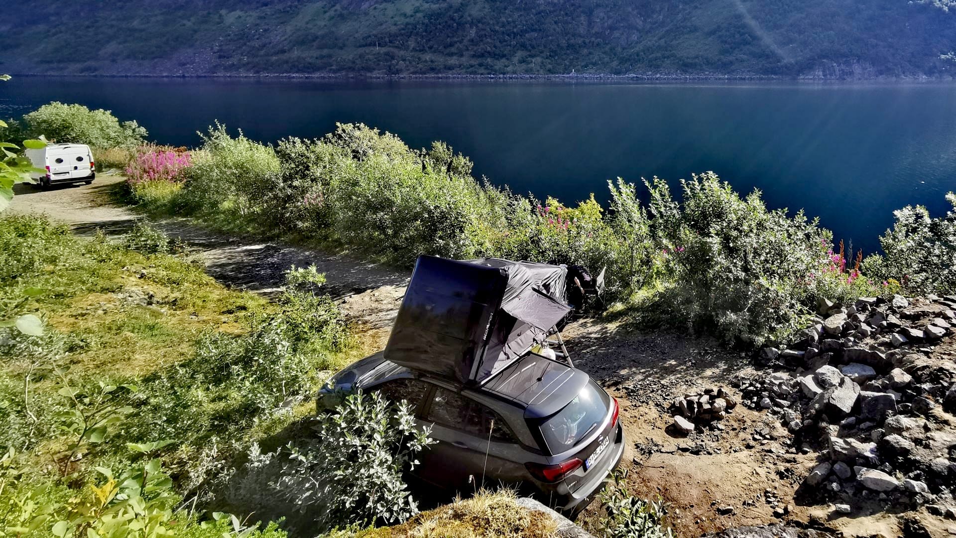 Stellplatz oberhalb eines Fjords an der Tunnelumfahrung nahe des Segla auf Senja bei strahlendem Sonnenschein