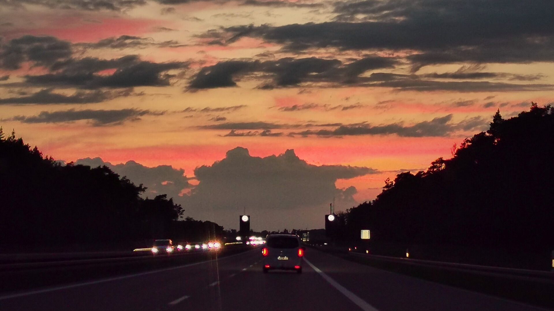 Abendstimmung mit rötlich leuchtendem Himmel auf der Autobahn in Richtung Rostock