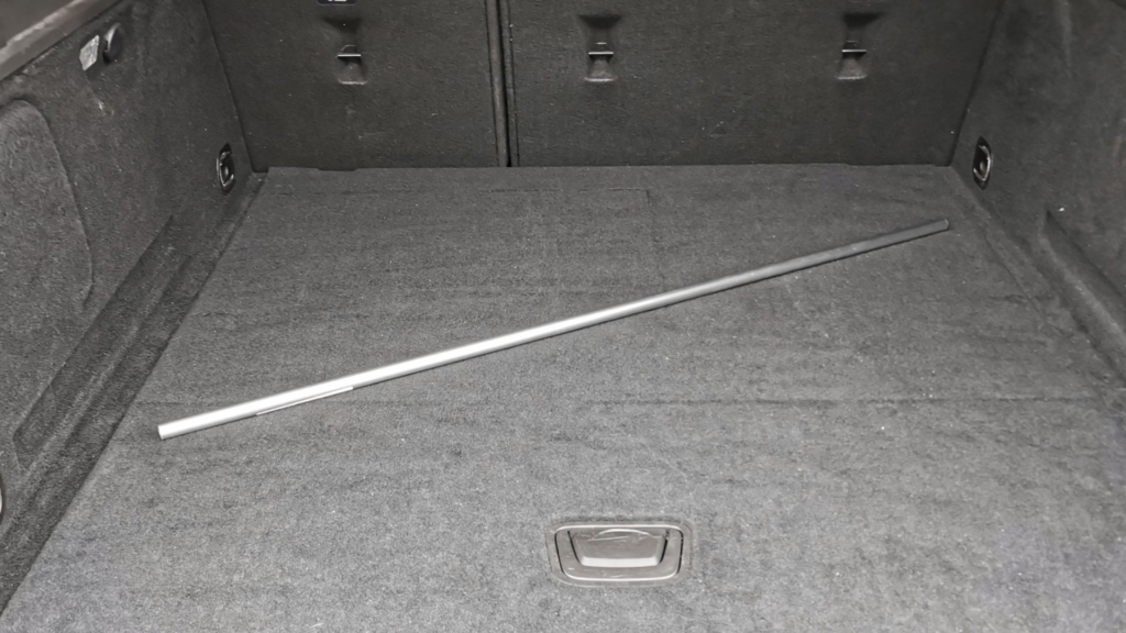Ein 100 cm langes, silbernes Alurohr mit 16 mm Durchmesser liegt quer im leeren Kofferraum eines Kombis.