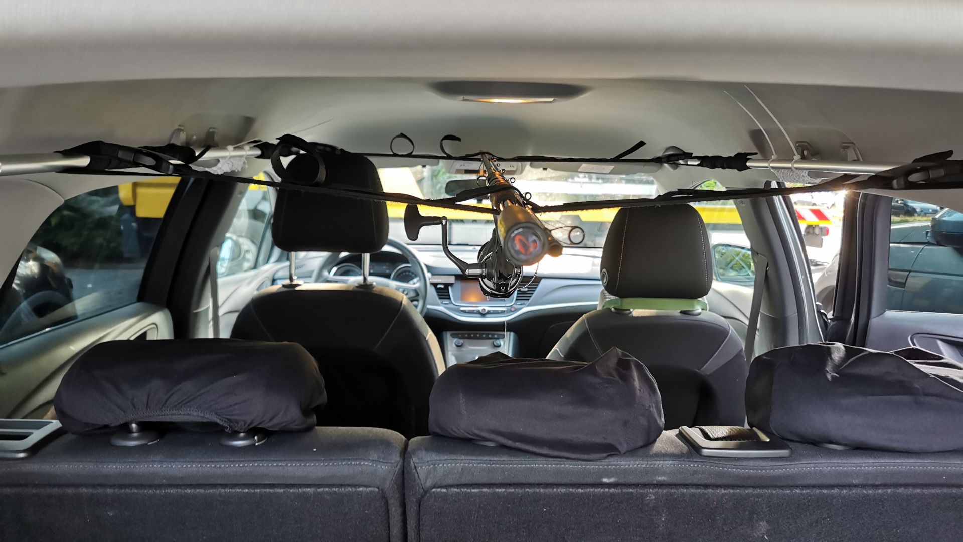 Fertig montiertes Rutentransportsystem aus der Perspektive des geöffneten Kofferraums - eine Angelrute ist exemplarisch befestigt und veranschaulicht die Fixierung.