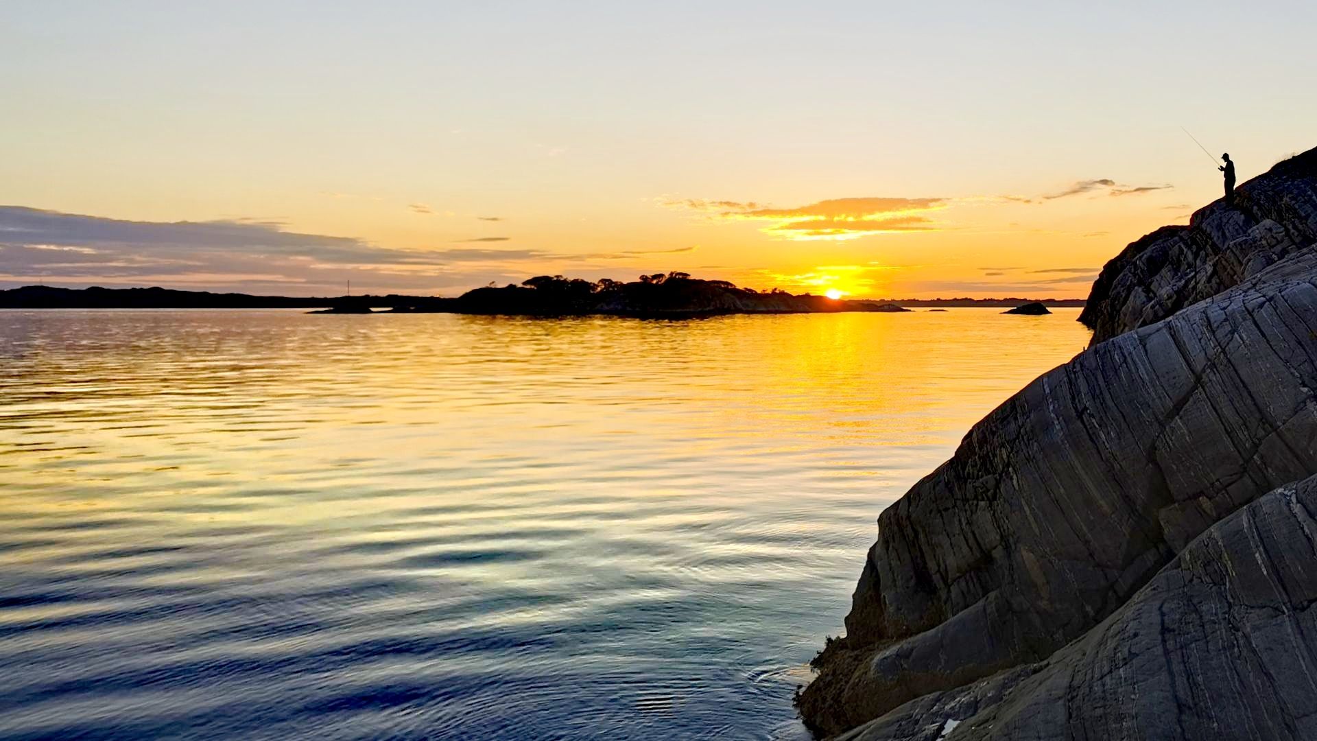 Sonnenuntergang über dem Meer auf Askøy mit Angler-Silhouette – stimmungsvolles Finale einer Angeln mit Dachzelt-Tour bei Bergen