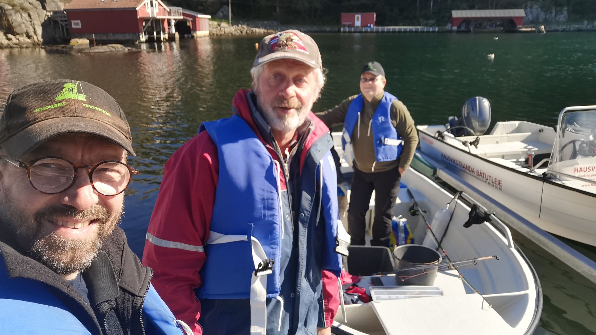 Autor mit zwei Freunden auf einem gemieteten Boot bei Hausvikstranda nahe Lyngdal, Angelutensilien liegen bereit – Start zum Angeln bei der Dachzelt-Etappe in der Gegend von Mandal und Lyngdal