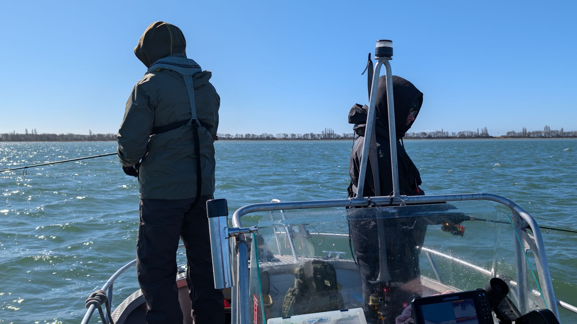 Konzentrierte Spinnfischer stehen im frischen Wind auf der Ostsee am Bug des Bootes beim Guiding auf Meerforelle vor Rügen